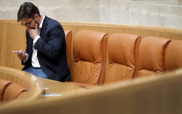 El portavoz parlamentario de Cs consulta su teléfono móvil en una sesión anterior del Parlamento de La Rioja.