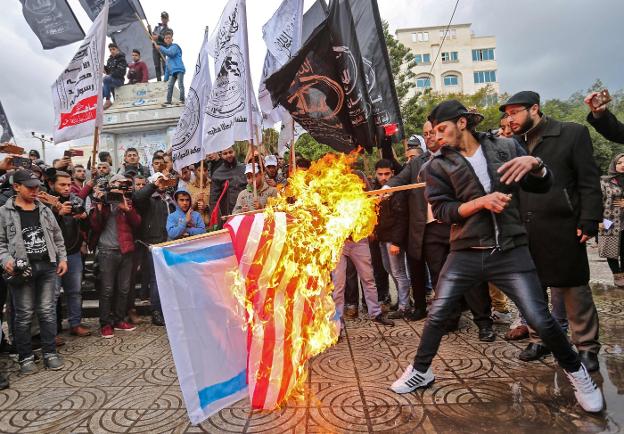 Jóvenes palestinos queman las banderas estadounidense e israelí en Gaza. :: MAHMUD HAMS / afp