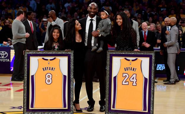 Kobe Bryant y su familia, junto a las dos camisetas. 