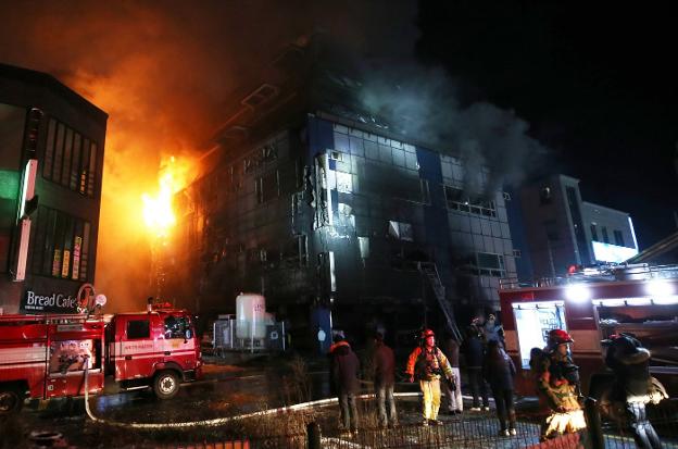 Los bomberos actúan, ayer por la noche, en el edificio incendiado en Jecheon (Corea del Sur). :: Yonhap / efe

