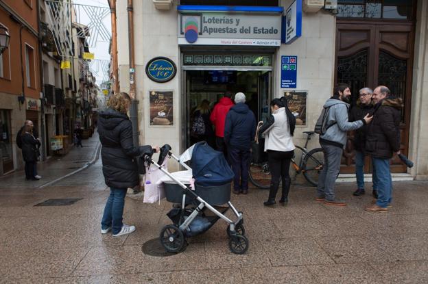 Clientes comprando lotería del Niño en una administración de Logroño. :: 