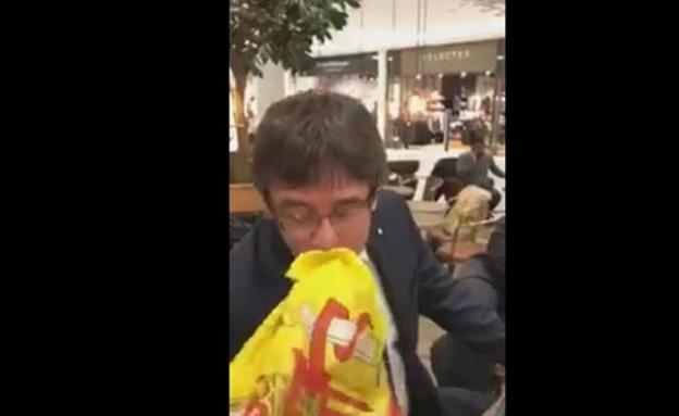 Un joven hace besar la bandera de España a Puigdemont