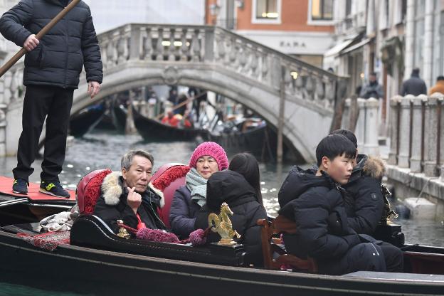 Un grupo de turistas japoneses, en Venecia. Arriba, el recibo de la cuenta de Osteria da Luca. :: afp