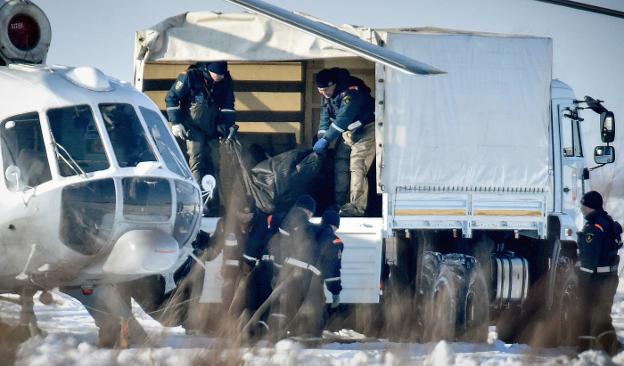 Los equipos de emergencia trasladan los cuerpos de los pasajeros en un camión frigorífico. :: V. M. / afp