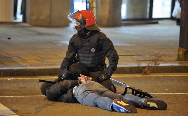 Un ertzaina reduce a uno de los violentos.