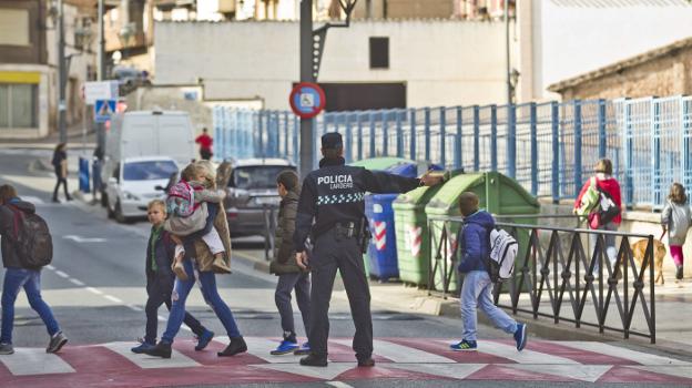 Un policía local facilita el paso de los peatones a la salida del colegio González Gallarza de Lardero. :: justo rodríguez