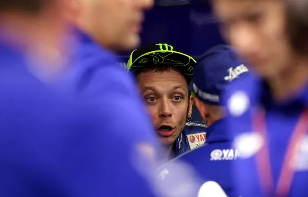 El piloto italiano Valentino Rossi habla con los miembros de su equipo tras la carrera. :: rEUTERS