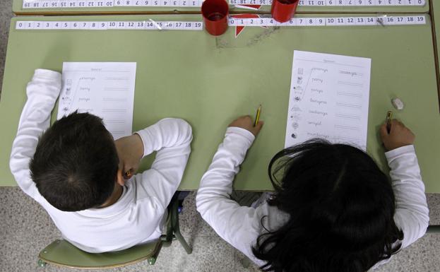 Dos niños hacen ejercicios en un aula de un colegio público de El Masnou (Barcelona).