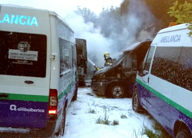 Un bombero apaga, ayer, el incendio provocado en el polígono de Arrigorriaga en el que resultaron destrozadas 35 ambulancias. :: LUIS CALABOR