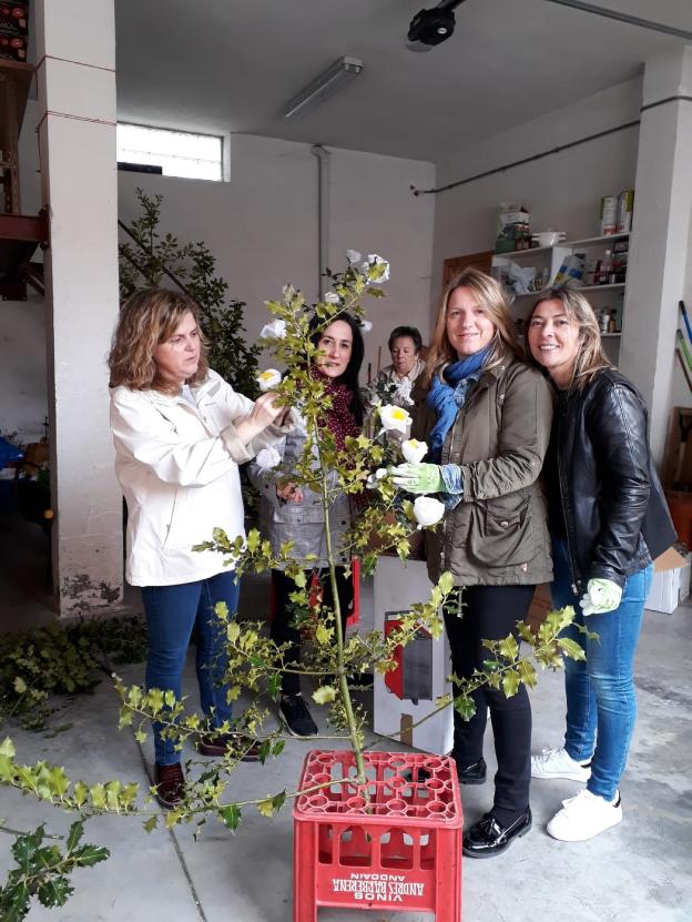 Varias mujeres de Sorzano engalanan los ramos de acebo. :: p. h.