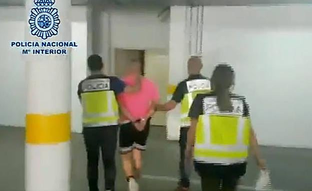 Varios agentes guían a un detenido a dependencias policiales. 