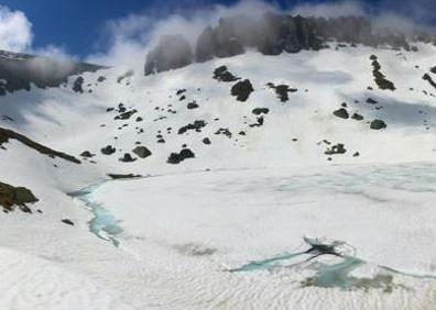 Imagen secundaria 1 - Arriba, una de las primeras cascadas que forma el Urbión al pie de la cumbre. martínez . A la izquierda, la laguna, helada, bajo Peñas Claras. (Fotos David Martínez). A la derecha, David Martínez, este invierno camino del Urbión, sentado en un poste enterrado en la nieve.: