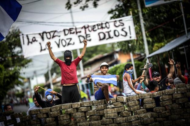 Jóvenes manifestantes se reúnen detrás de una barricada durante una protesta en la ciudad de Masaya. :: bienvenido velasco / efe