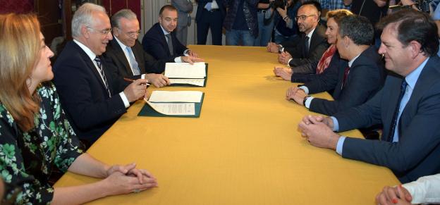 Ceniceros y Fainé firman el convenio ante la presencia de consejeros y responsables de La Caixa. :: m.h.