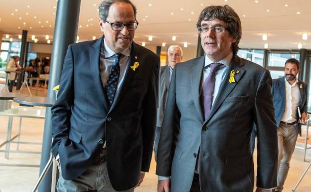 El presidente de la Generalitat, Quim Torra (izda), conversa con su antecesor en el cargo, Carles Puigdemont. 