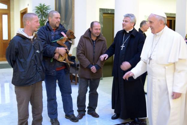 Con los pobres. El nuevo cardenal, entre Francisco y un grupo de indigentes que se acercaron al Papa para felicitarle en su cumpleaños. reuters