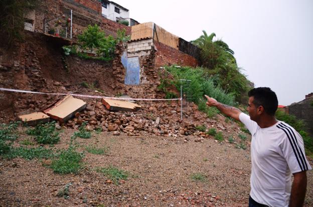 Francisco señala la parte del patio de su casa que se ha venido abajo como consecuencia del derrumbe de un muro de Murallas. :: 