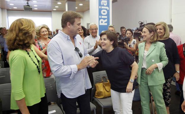 Imagen. Soraya Sáenz de Santamaría, en el centro de la imagen, recibe el aplauso de sus compañeros de partido. 