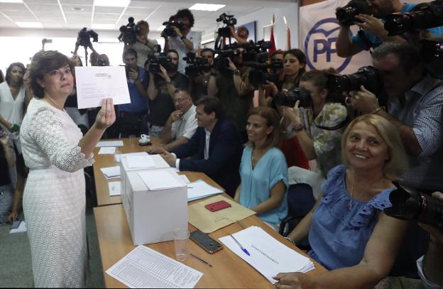 Sáenz de Santamaría enseña su papeleta durante las votaciones en Madrid. :: j. .lizón (EFE)