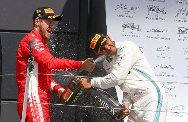 Sebastian Vettel (i) y Lewis Hamilton celebran en el podio su primera y segunda posición en el GP de Gran Bretaña. :: GEOFF CADDICK / EFE