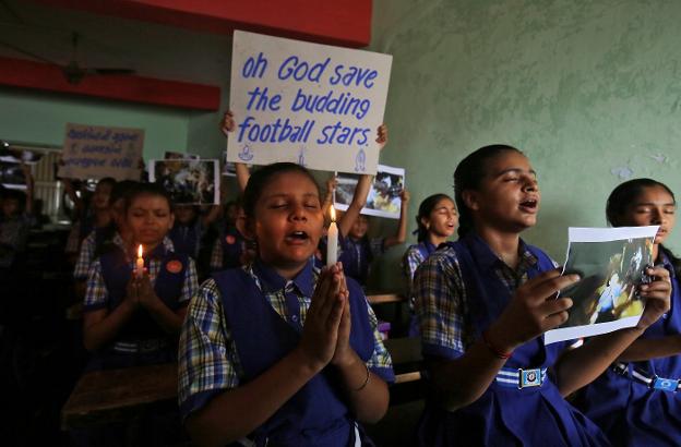 Estudiantes de un colegio en India rezan por el rescate de los niños futbolistas atrapados en una cueva de Tailandia. :: Amit Dave / reuters