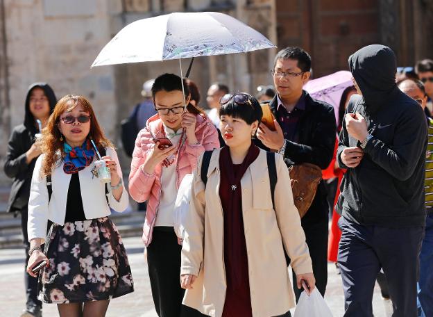 Varios turistas chinos caminan por el centro de Valencia. :: r. solsona