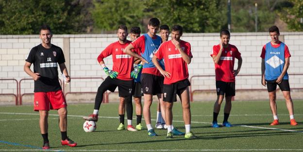 Los jugadores de la UD Logroñés atienden a las explicaciones de Sergio Rodríguez en el entrenamiento vespertino del jueves. :: díaz uriel