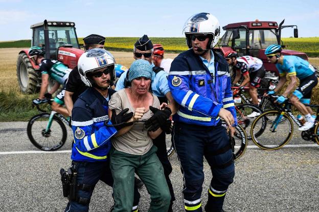 Una agricultora se resiste a que tres policías la retiren de la carretera. ::  Jeff PACHOUD/AFP