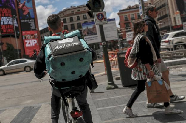 Un repartidor de Deliveroo entregando pedidos por las calles del centro de Madrid. :: s. vera / reuters