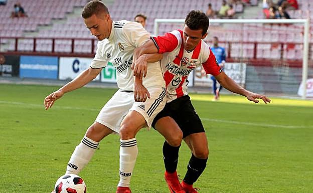 Dos jugadores disputan un balón.i