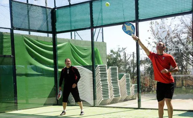 Dos deportistas juegan al pádel por parejas.