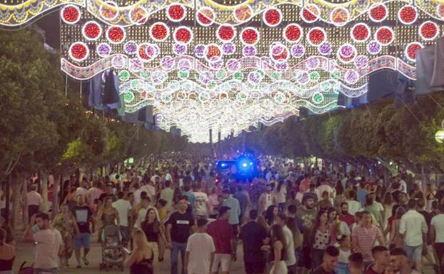 Un furgón de la Policía en una concurrida calle del real de la Feria de Málaga.