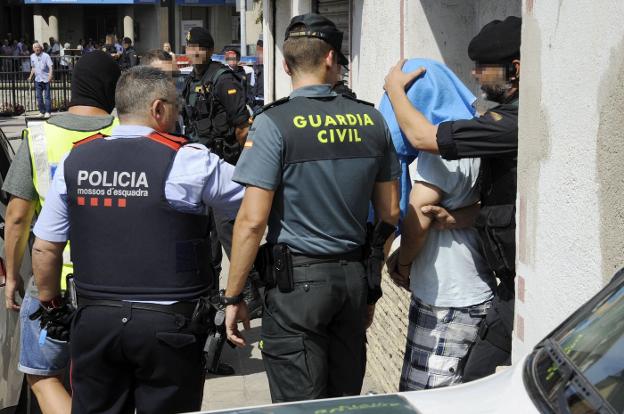 Agentes de la Guardia Civil y los Mossos practican una detención en Ripoll, el año pasado, tras los atentados de Barcelona. :: Robin Townsend / efe