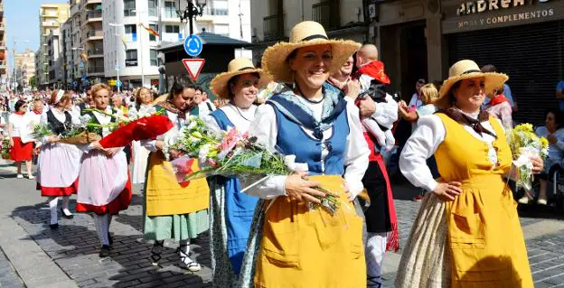 Danzantes del grupo Coletores y calagurritanas vestidas con el traje regional, en el desfile para acudir a la ofrenda de flores a los santos. 