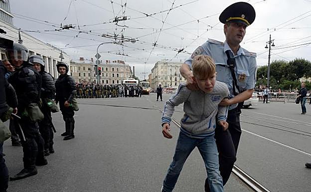 Un agente se lleva a un menor de la manifestación en San Petersburgo. 