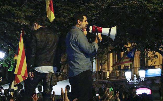 Jordi Cuixart (izquierda) y Jordi Sànchez (dcha.) se dirigen a las personas congredadas frente a la Consejería de Economía.