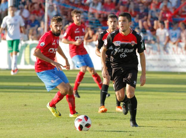 Carles Salvador juega el balón, por medio, ante la vigilancia de Parla. Detrás de ambos, Rayco. :: f.d.