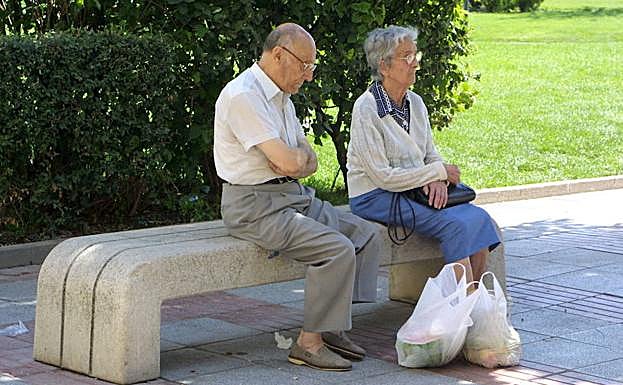 Una pareja de ancianos descansa en una plaza de Miranda de Ebro. 