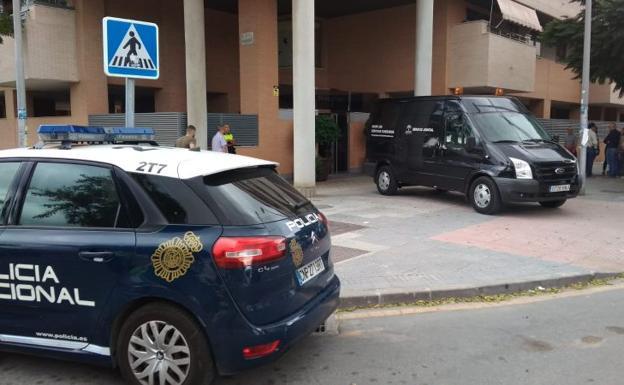 Un coche funerario sale del bloque de viviendas en el que ha ocurrido el suceso.