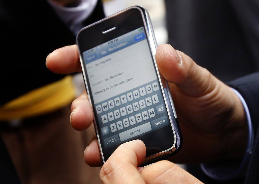 Un hombre sostiene un teléfono móvil.