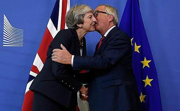 Jean-Claude Juncker saluda, ayer, a Theresa May.