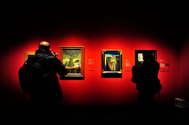 Dos visitantes contemplan dos cuadros de Óscar Domínguez y Salvador Dalí. :: Diego Pérez Cabeza / efe