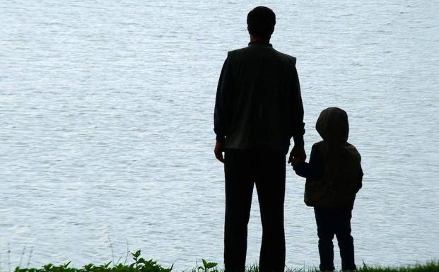 Un padre y un hijo contemplan el mar. 