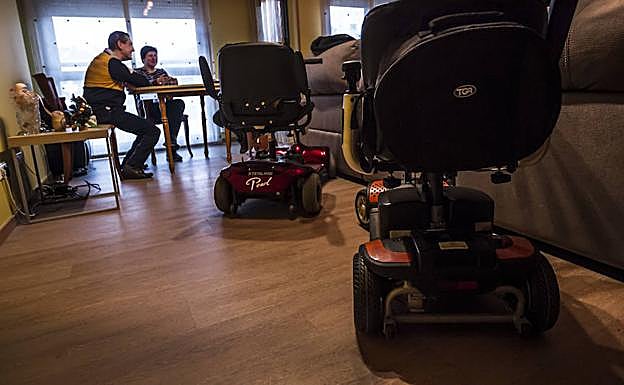 Pablo y Pilar aparcan sus sillas eléctrónicas en el salón de su casa. 