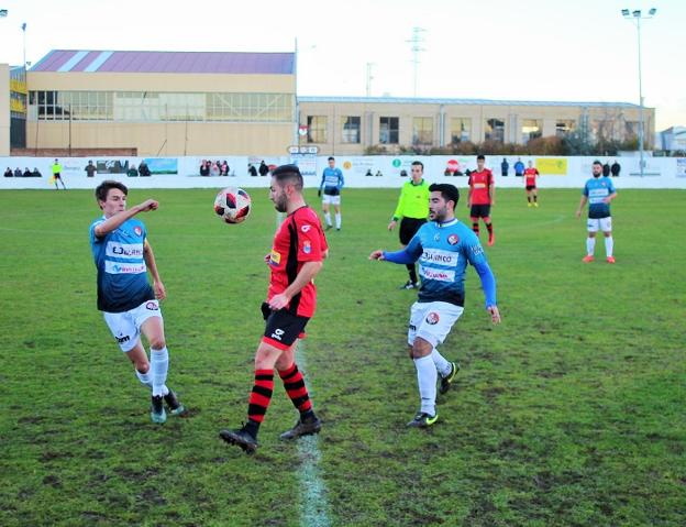 El calceatense Jorge García controla el balón ante los logroñeses Miguel y Rojas.