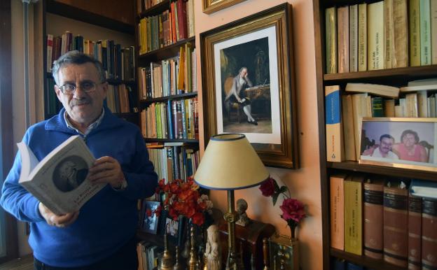 José Manuel San Baldomero, en su despacho, con su libro y junto al retrato de Jovellanos.