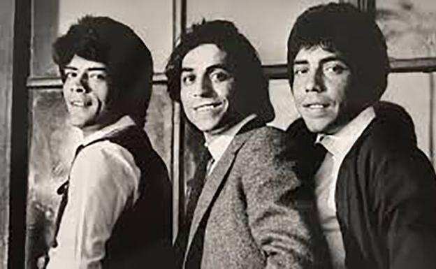 Imagen principal - Arriba, Enrique Salazar posa flanqueado por sus hermanos, con los que formaba 'Los Chunguitos'. Él era el compositor y vocalista. Debajo, el álbum que recoge 'Me quedo contigo' y el cartel de la película 'Perros callejeros' en la que también sonaba el tema. 