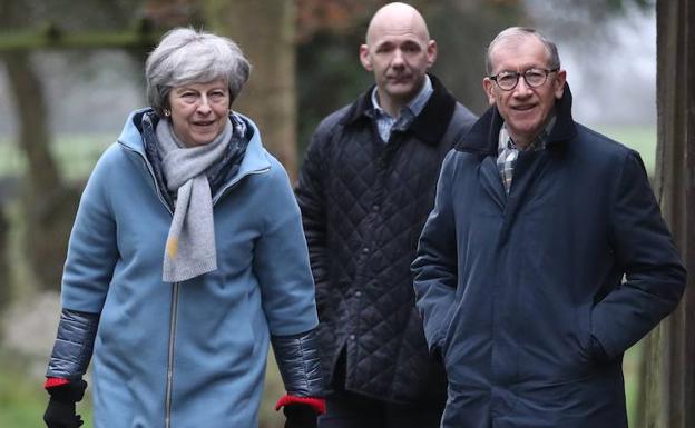 Theresa may (I) camina con su marido y un colaborador. 