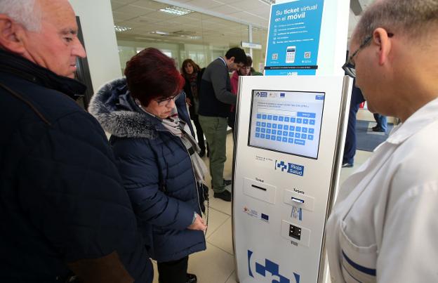 Usuarios del CARPA extraen el tíquet para acceder a la consulta concertada ayer. :: 