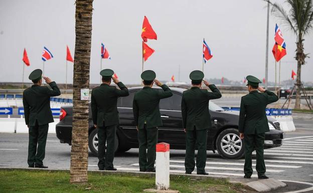 El personal de seguridad vietnamita saluda a un automóvil.